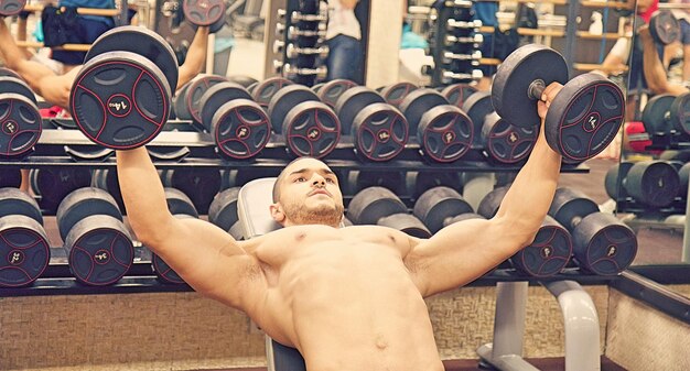 Photo shirtless man exercising at gym