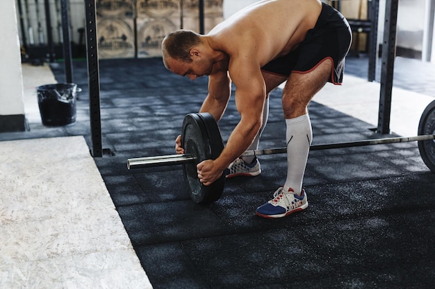 Foto uomo senza maglietta che si esercita in palestra