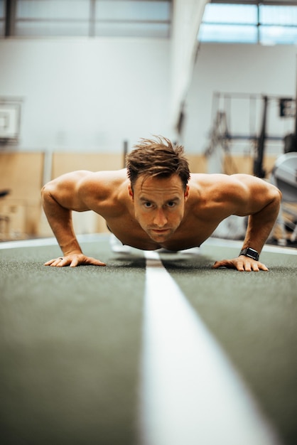 Photo shirtless man exercising in gym