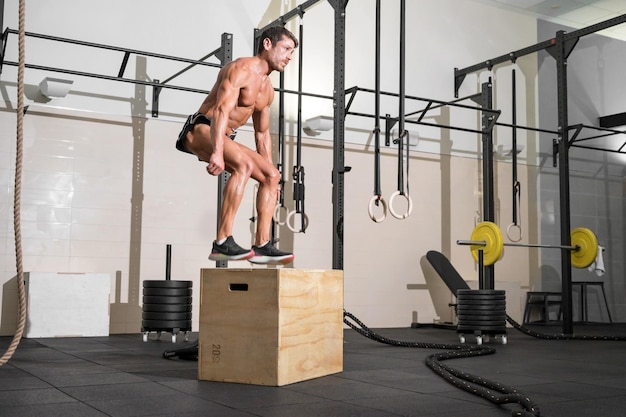 Photo shirtless man exercising at gym