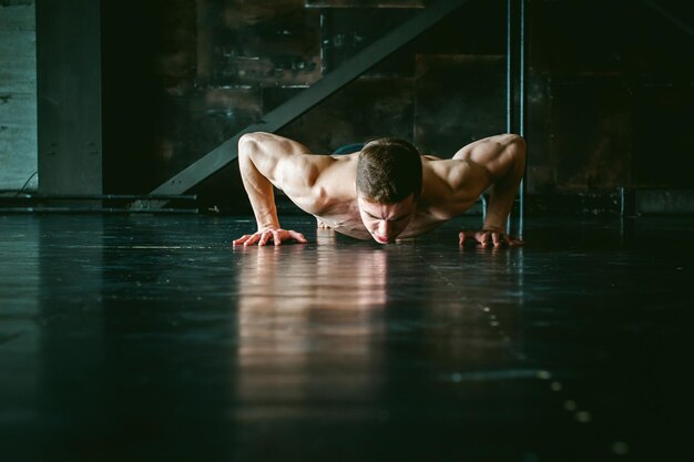 Фото Мужчина без рубашки занимается на полу.