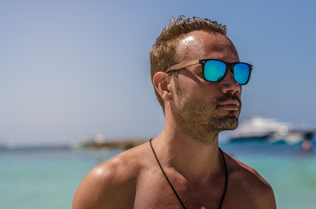 Shirtless man genieten van het strand