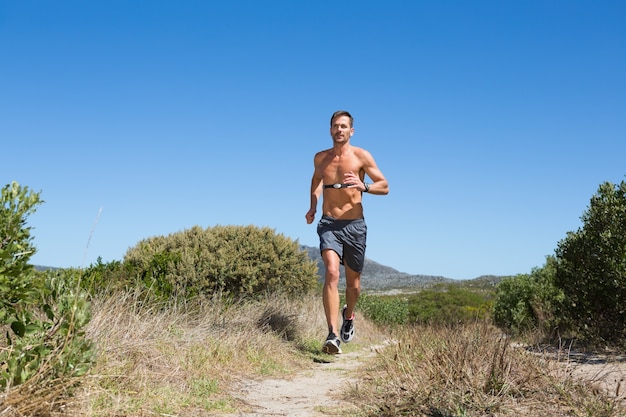 Shirtless man joggen met hartslagmeter rond de borst