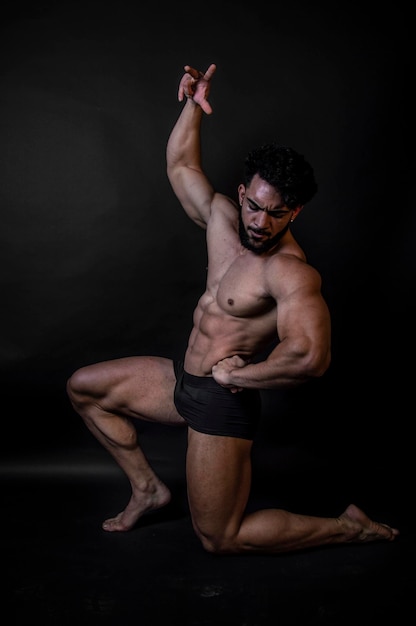 Photo shirtless man kneeling against black background