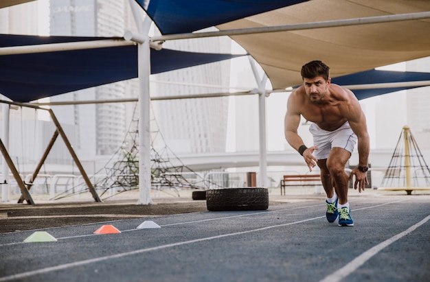 Shirtless man running on track