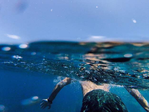 Foto uomo senza camicia in mare contro il cielo