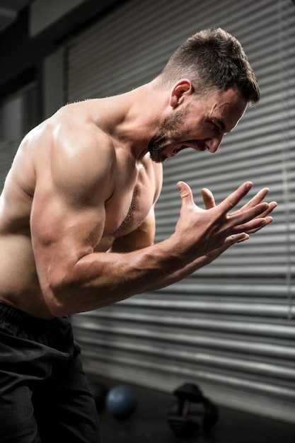 Shirtless man shouting at the crossfit gym