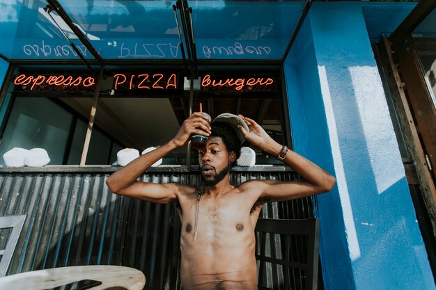 Shirtless man sitting at a cafe