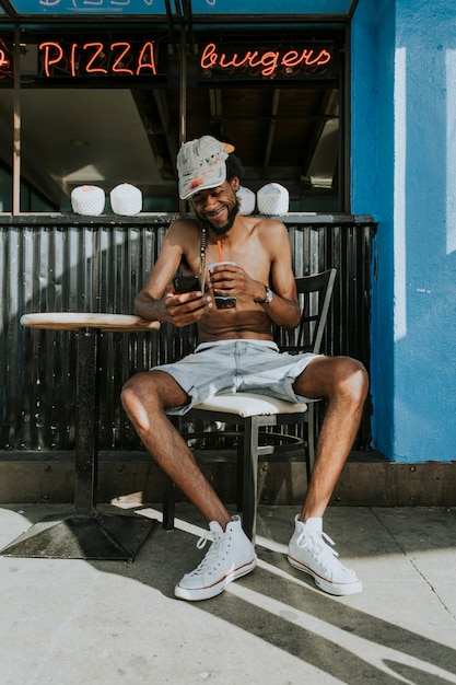 Shirtless man sitting at a cafe