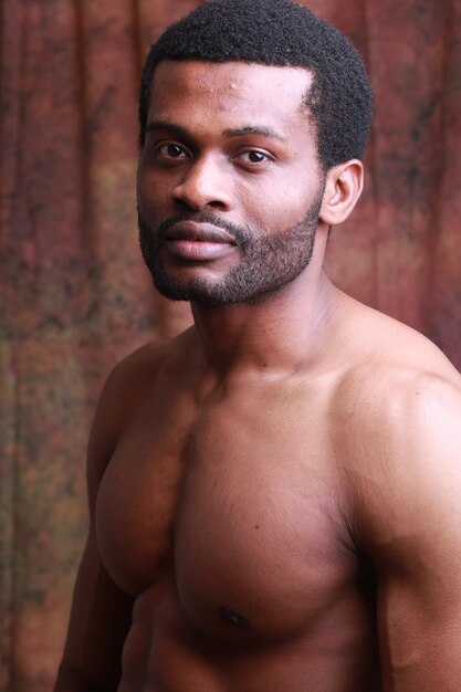 Photo shirtless man standing against wall