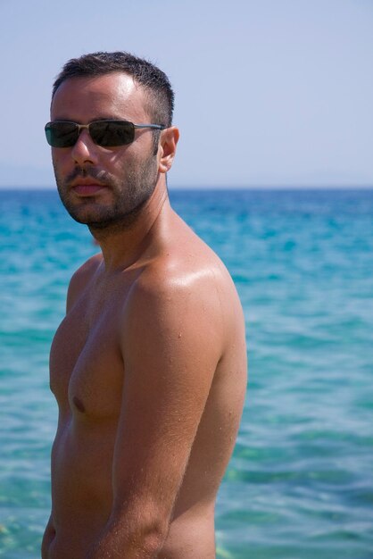 Photo shirtless man standing at beach