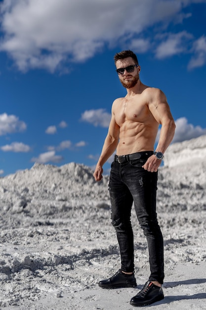 Shirtless man standing in the snowy landscape A man with no shirt standing in the snow