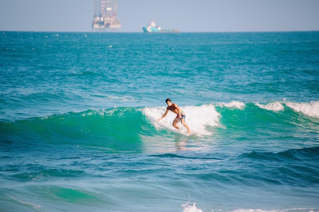 A shirtless man surfing on the beach photo