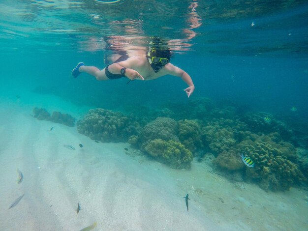 Shirtless man swimming in sea