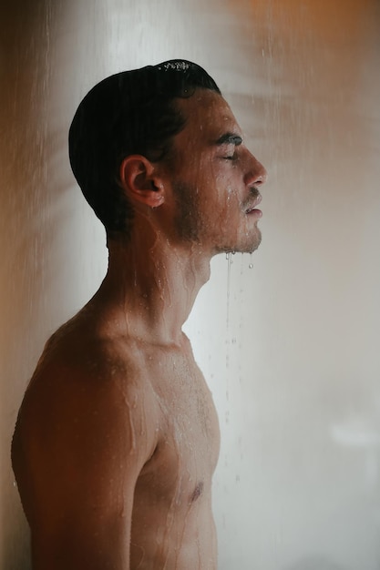 Photo shirtless man taking shower in bathroom