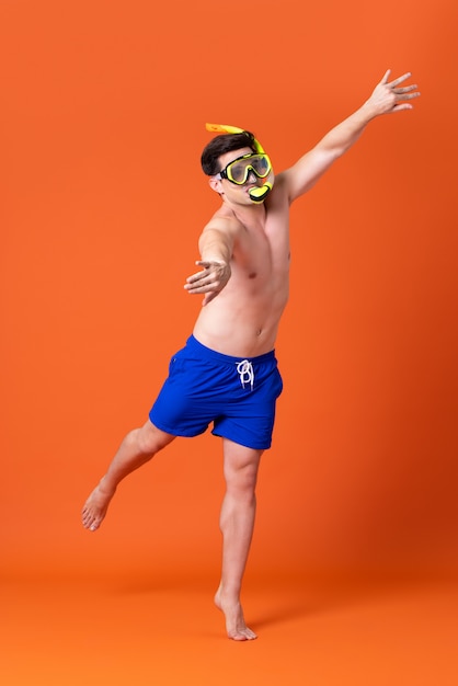 Shirtless man wearing snorkel mask doing swimming gesture