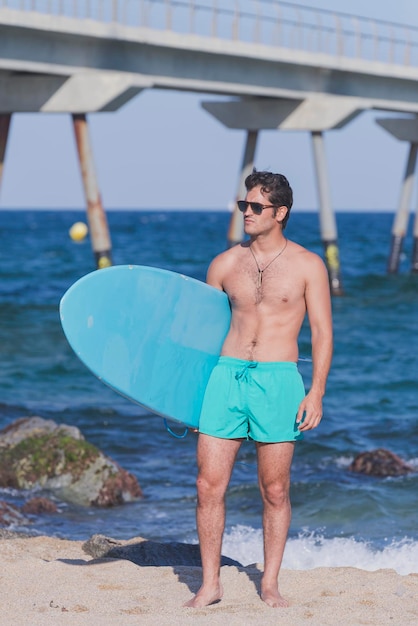 Shirtless man with surfboard at beach