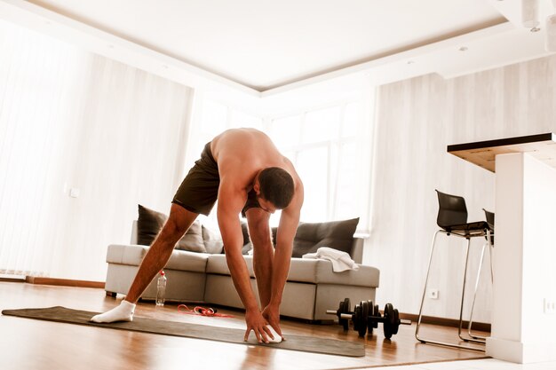 Shirtless man working out at home