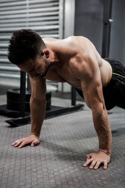 Shirtless mens die duw omhoog doen bij de crossfitgymnastiek