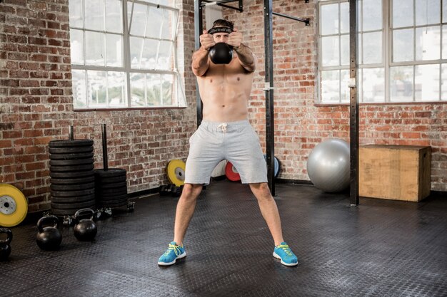 Shirtless mens die kettlebell opheft