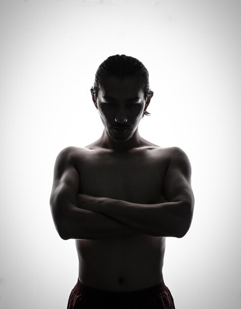 Photo shirtless mid adult man with arms crossed while standing against white background