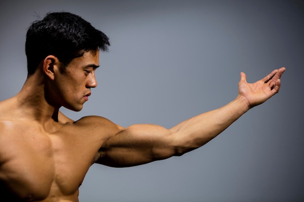 Photo shirtless muscular man standing against wall