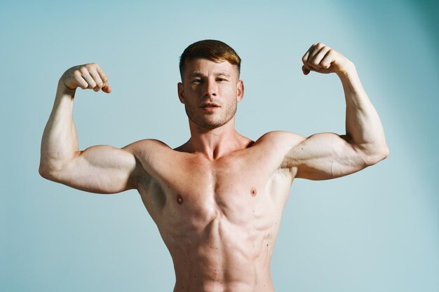 Shirtless young man exercising against white background