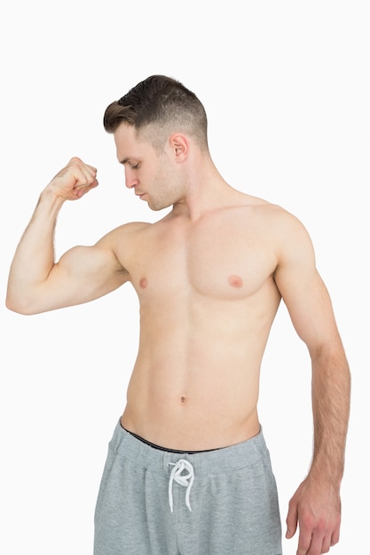 Shirtless young man flexing muscles