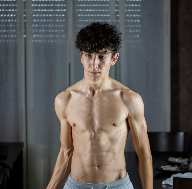 Photo shirtless young man looking away while standing at home