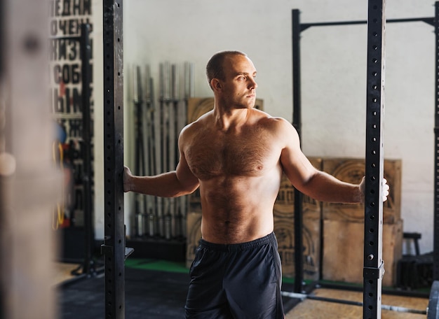 shirtless young man standing in gym