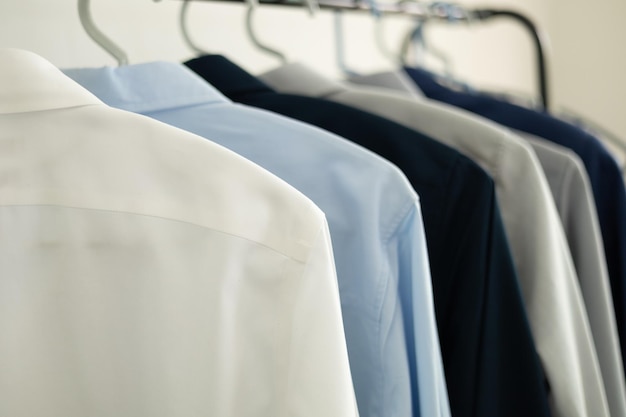 Рубашки упорядоченно развешены в магазине одежды.