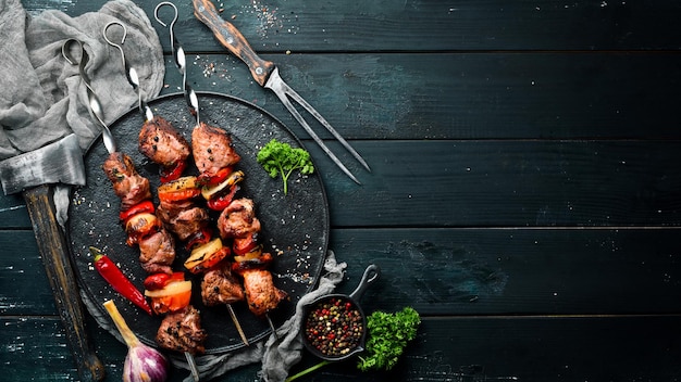 Shish kebab BBQ-vlees met uien en tomaten Op een zwarte achtergrond Bovenaanzicht Vrije ruimte voor uw tekst Rustieke stijl