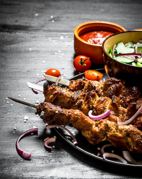 Shish kebab of pork and salad.