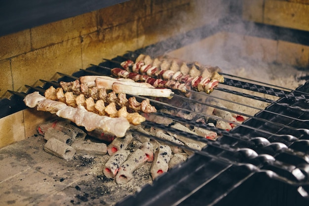 Shish kebab on skewers from different types of meat is fried on the grill