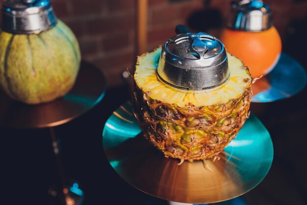 Photo shisha with fruit bowl with colorful smoke in hookah bar closeup