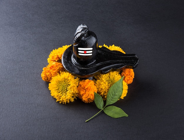 Photo shiva linga decorated with flowers & bel patra or leaf and haldi kumkum for pooja or worshipping of lord shiva or shankar bhagwan