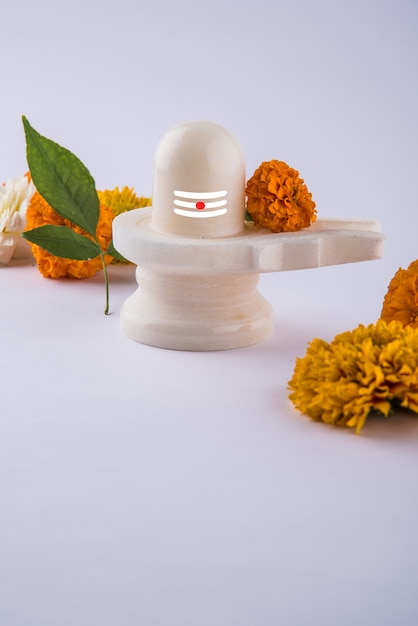 Photo shiva linga decorated with flowers & bel patra or leaf and haldi kumkum for pooja or worshipping of lord shiva or shankar bhagwan