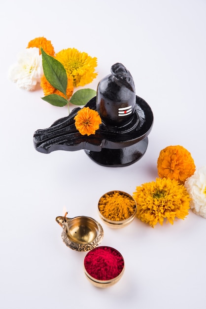 Shiva Linga decorated with flowers & bel patra or leaf and haldi kumkum for Pooja or worshipping of Lord shiva or Shankar bhagwan