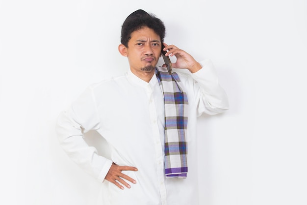 shock and confused asian muslim man using mobile phone isolated on white background