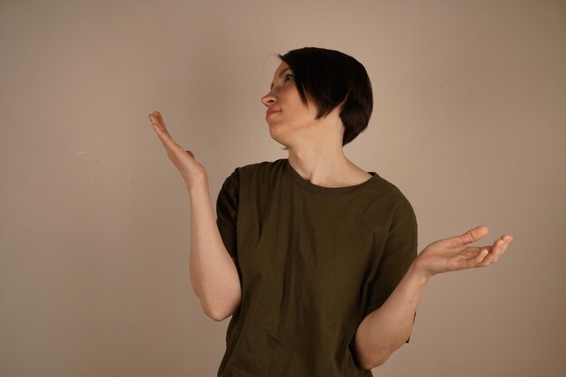 Shock and surprise concept Stressed confused girl with arms outstretched isolated over gray studio wall copyspace