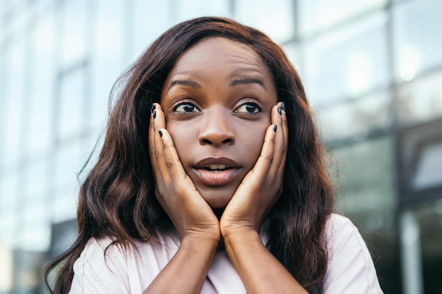 Shocked african american woman standing outside