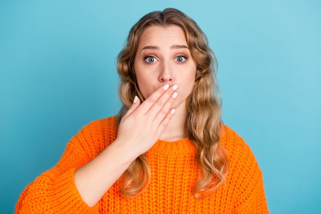 Shocked amazed young woman standing covering mouth with hands looking camera isolated studio portrait