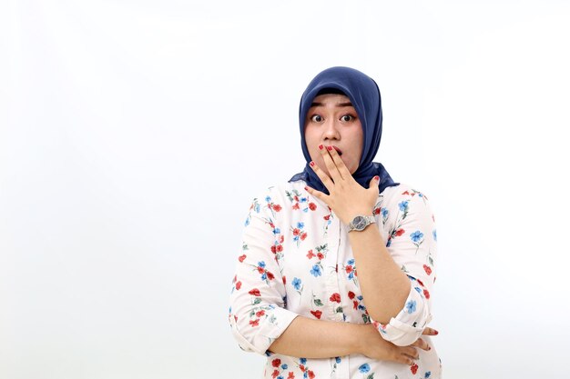 Shocked asian muslim woman standing while covering her mouth isolated on white background