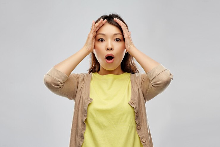Photo 충격을 받은 아시아 여성이 머리를 붙잡고 있다.