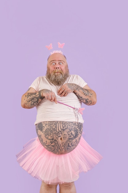 Photo shocked bearded man with overweight in fairy costume on purple background