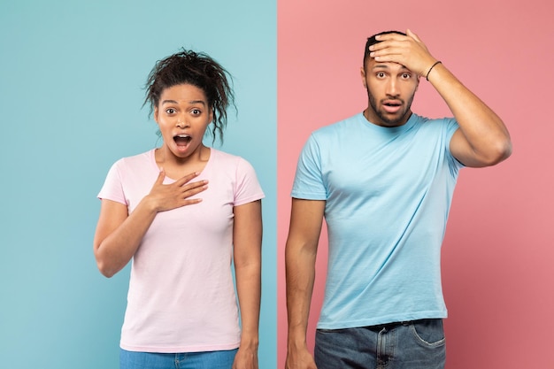 Photo shocked black couple opening mouths in shock woman putting hand on heart man touching head pink and blue background