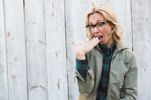 Shocked blonde in glasses gesturing 