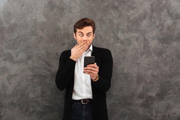 Shocked businessman chatting by mobile phone.
