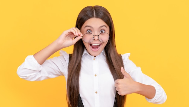 Shocked child long hair look like nerd thumb up teen girl look through eyeglasses