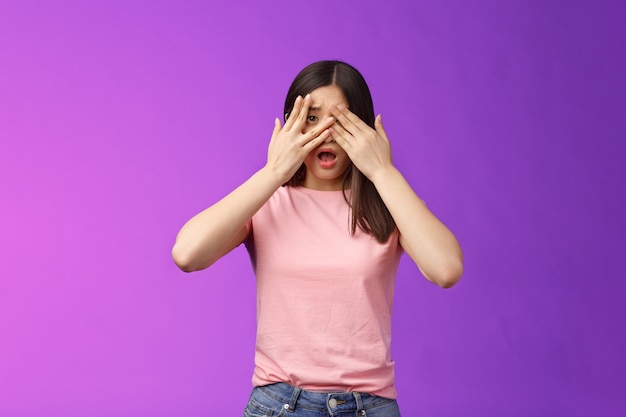Shocked concerned asian girl witness terrible crime feel insecure scared, close eyes frightened shook, open mouth, gasping upset, standing stupor drop jaw, pose purple background